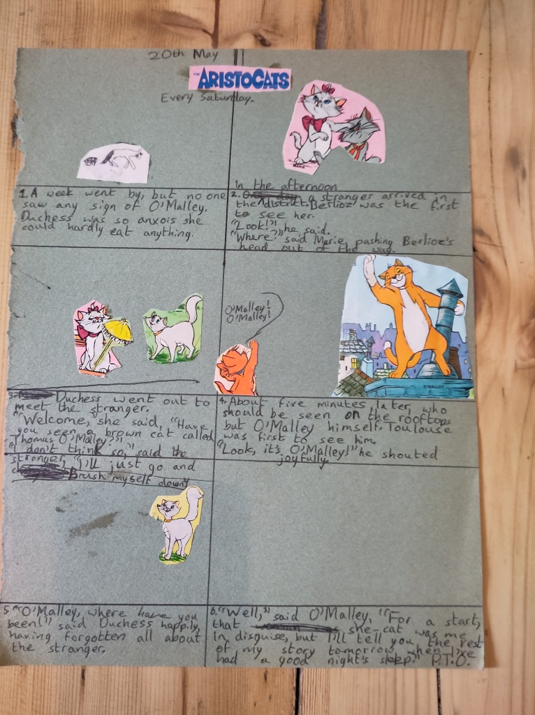 A page from a child's scrapbook, with cartoon characters from the Aristocats film cut out of chocolate wrappers, and arranged in cartoon frames with a story written in captions  underneath.