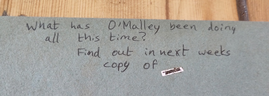 A child's handwriting in a scrapbook: "What has O'Malley been doing all this time? Find out in next week's copy of The Aristocats!"
